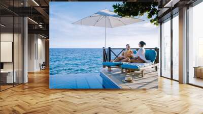 Curacao, couple man and woman mid age relaxing by the swimming pool during vacation, men and girl by pool in Curacao during holiday at a tropical island luxury vacation Wall mural