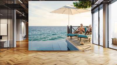 Curacao a couple man and woman mid age relaxing by the swimming pool during vacation, men and girl by the pool in Curacao during holiday at a tropical island luxury vacation Wall mural