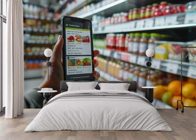 hand holding mobile phone, woman in the supermarket with an online shopping list application on a mobile phone, a woman in the shop looking in a mobile phone Wall mural