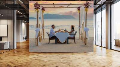 Romantic dinner on the beach in Phuket Thailand, couple man and woman mid age Asian woman and European man having dinner on the beach in Thailand during sunset. Wall mural