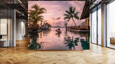 young man at the beach during vacation at the tropical islands of the Seychelles, men in infinity pool during sunset at the Seychelles La Digue Island Wall mural