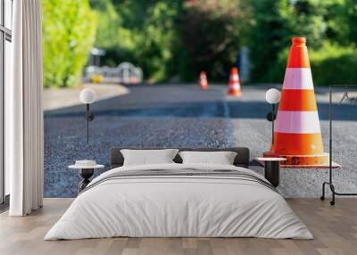 Construction cones marking part of road with a layer of fresh asphalt. Wall mural