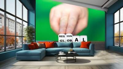 Hand turns dice and changes the word global to regional. Wall mural