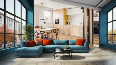 Cozy scandinavian open space with dining, living room and kitchen with design sofa and family table. Bright and sunny room with big windows and brown wooden parquet.	 Wall mural