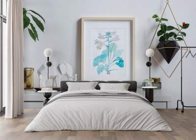 Modern and stylish home interior, floral poster mock up with wooden photo frame, avocado plant, elephant figure and hanging plant in geometric pot on white wall background. Concept of white shelf. Wall mural