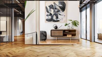 Scandinavian and design home interior of living room with wooden commode, design black lamp, rattan basket, plants and elegant accessories. Stylish home decor. Template. Mock up poster paintings.  Wall mural