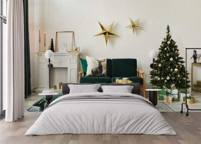 Stylish christmas living room interior with green sofa, white chimney, christmas tree and wreath, stars, gifts and decoration. Family time. Template. Wall mural