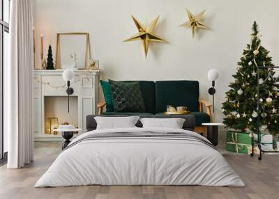 Stylish christmas living room interior with green sofa, white chimney, christmas tree and wreath, stars, gifts and decoration. Family time. Template. Wall mural