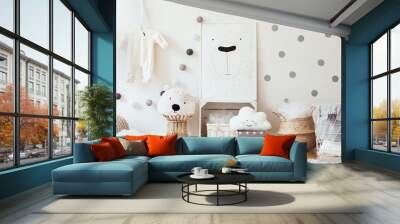 Stylish scandinavian child room with mock up photo poster frame on the pattern wall, boxes, teddy bear and toys.Cute modern interior of playroom with white walls, wooden accessories and colorful toys. Wall mural