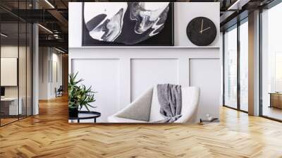 Stylish scandinavian home interior of living room with design gray armchair, modern stool, black coffee table, modern paintings, decoration, plant and elegant personal accessories in home decor. Wall mural