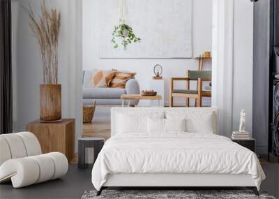 the modenr boho interior of living room in cozy apartment with design coffee table, gray sofa, woode Wall mural