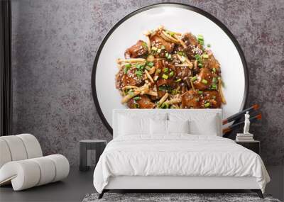 Asian fried beef steak with shimeji mushrooms in teriyaki sauce with green onion and sesame close-up in a plate on the table. Horizontal top view from above Wall mural