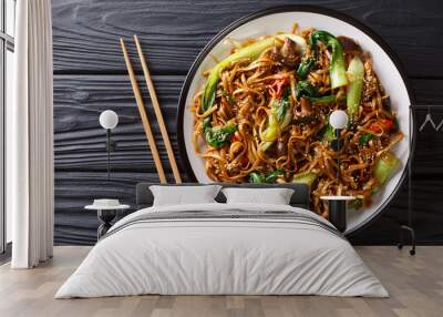 Asian vegetarian food udon noodles with baby bok choy, shiitake mushrooms, sesame and pepper close-up on a plate. horizontal top view Wall mural