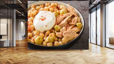 Chickpeas in broth served with canned tuna, olives and poached egg close-up in a bowl on the table. Horizontal Wall mural