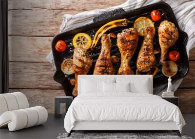 Freshly cooked grilled chicken drumstick legs with vegetables in a grill pan close-up. horizontal top view Wall mural