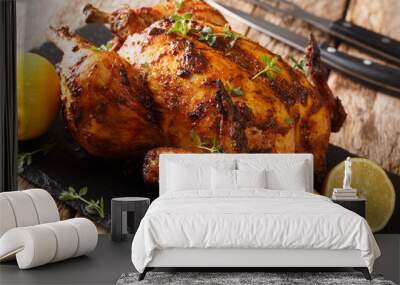 Freshly cooked rotisserie chicken with ginger and spices close-up on a slate board. horizontal Wall mural