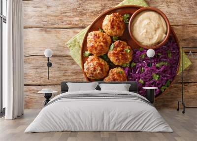 Frikadeller or Danish Meatballs are savory meatballs served with rich creamy sauce and stew red cabbage close up in the plate on the table. horizontal top view from above Wall mural