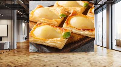 Hasselback pear in puff pastry fresh from the oven closeup on the wooden board on the table. Horizontal Wall mural