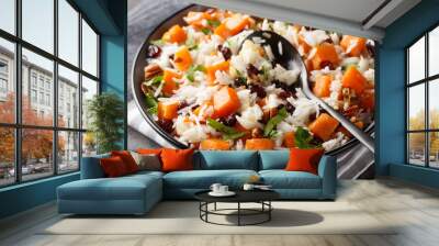 Healthy vegetarian pilaf with sweet potatoes, pecans, onions and dried cranberries close-up in a bowl on the table. Horizontal Wall mural