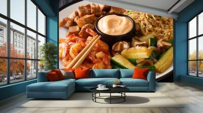 Hibachi dish consisting of fried rice with egg, shrimp, steak and vegetables served with sauce closeup in a plate. horizontal Wall mural