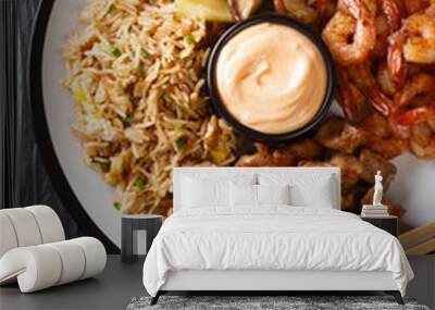 Hibachi fried rice with egg, shrimp, steak and vegetables close-up in a plate. Vertical top view Wall mural