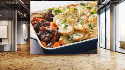 Lancashire Hot Pot, lamb and vegetables topped with sliced potatoes and oven baked closeup in the baking dish on the table. Horizontal Wall mural