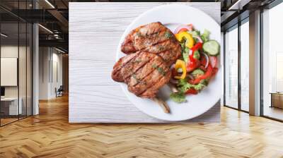 Pork meat grilled with fresh vegetable salad top view Wall mural