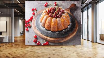 Rustic style cherry cake decorated with fresh berries and powdered sugar close-up on a wooden board on the table. Horizontal Wall mural