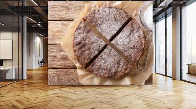 Swedish traditional dessert: kladdkaka chocolate sticky cake with powdered sugar close-up. horizontal top view from above Wall mural