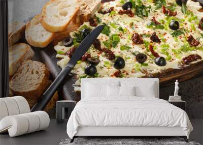 Tasty Butter board with fresh herbs, olives, sun-dried tomatoes served with bread closeup on dark background. Horizontal Wall mural