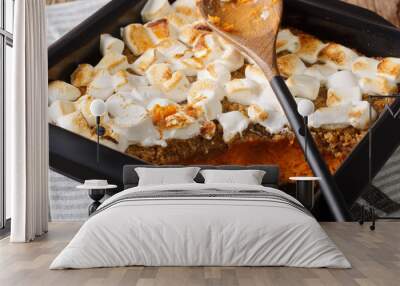 Traditional sweet potato dessert casserole with pecans and marshmallows close-up in a baking dish. horizontal Wall mural