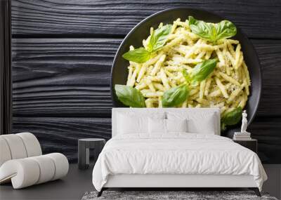 Traditional trofie pasta with green basil pesto and parmesan cheese close-up in a plate. Horizontal top view Wall mural