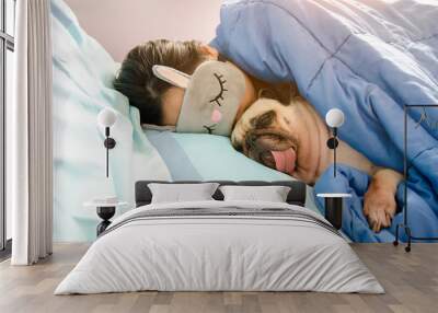 Sweet asian woman with mask and cute puppy pug dog is sleeping rest in the bed. Wall mural