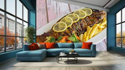 GRILLED HAMOUR Fish with gravy, lemon slice and tomato served in dish isolated on table closeup top view of grilled seafood Wall mural