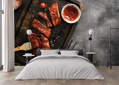 Delicious barbecued ribs seasoned with a spicy basting sauce and served on iron pan. Wall mural