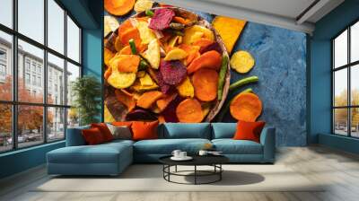 Dried vegetables chips from carrot, beet, parsnip and other vegetables on blue backgrounds. Organic diet and vegan food Wall mural