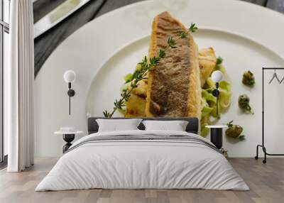 Fillet of halibut on a pillow of stewed leeks on the white plate. Wall mural