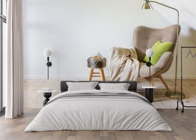 A reading chair / armchair with a lamp, blanket and a open book. Empty white wall in simple living room interior. Copy space Wall mural