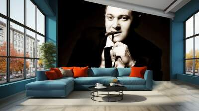 The man in style Chicago gangster with cigar  on dark background Wall mural