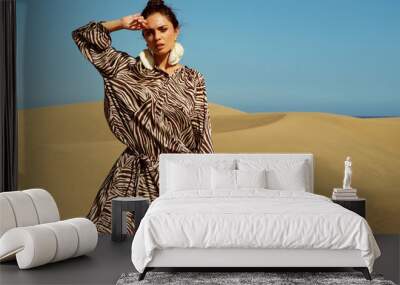 Fashion shoot of model wearing animal dress print on dessert. Wall mural