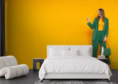 Shocked fashionable model wear in oversize green suit and high heels.  Wall mural