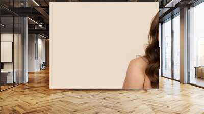 Very attractive young woman with curly brown hairs on light brown background. Wall mural