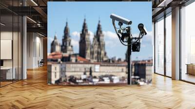 Scene of security cams on pole and Santiago de Compostela Cathedral blurred at background. Surveillance on Santiago de Compostela city concept Wall mural