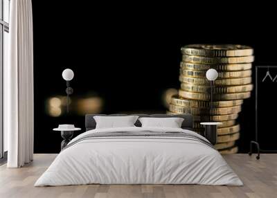 Golden coins close up. Stack of gold coins on a black background. Wall mural