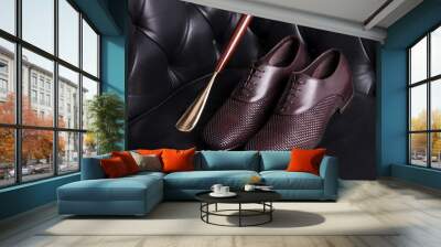 Men's shoes on a black sofa close-up. Pair of men's shoes and a golden spoon for shoes. Wall mural