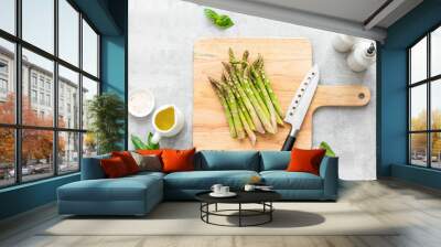 Asparagus cooking concept, top down view on a cutting board with fresh bunch of asparagus, lying down on a kitchen table Wall mural