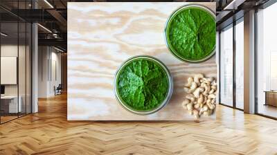 Bowl with green chutney sauce dip from leaves with cashew nuts. Top view with copy space. Wall mural