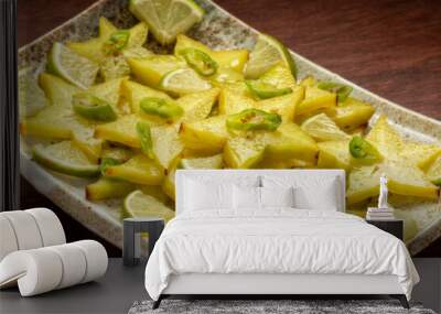 Homemade carambola or star fruit spicy salad with frozen green chili, lime pieces, and lime juice. Perfect condiment for grilled fish or a curry. Wooden table. Wall mural