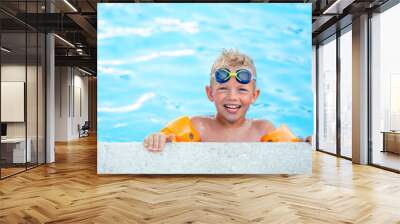 Portrait smiling boy in swimming pool, child in swimming glasses and inflatable sleeves. Summer travel hotel vacation or classes Wall mural