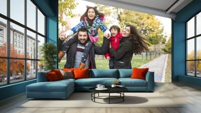 Autumn image of happy four members family in public park Wall mural